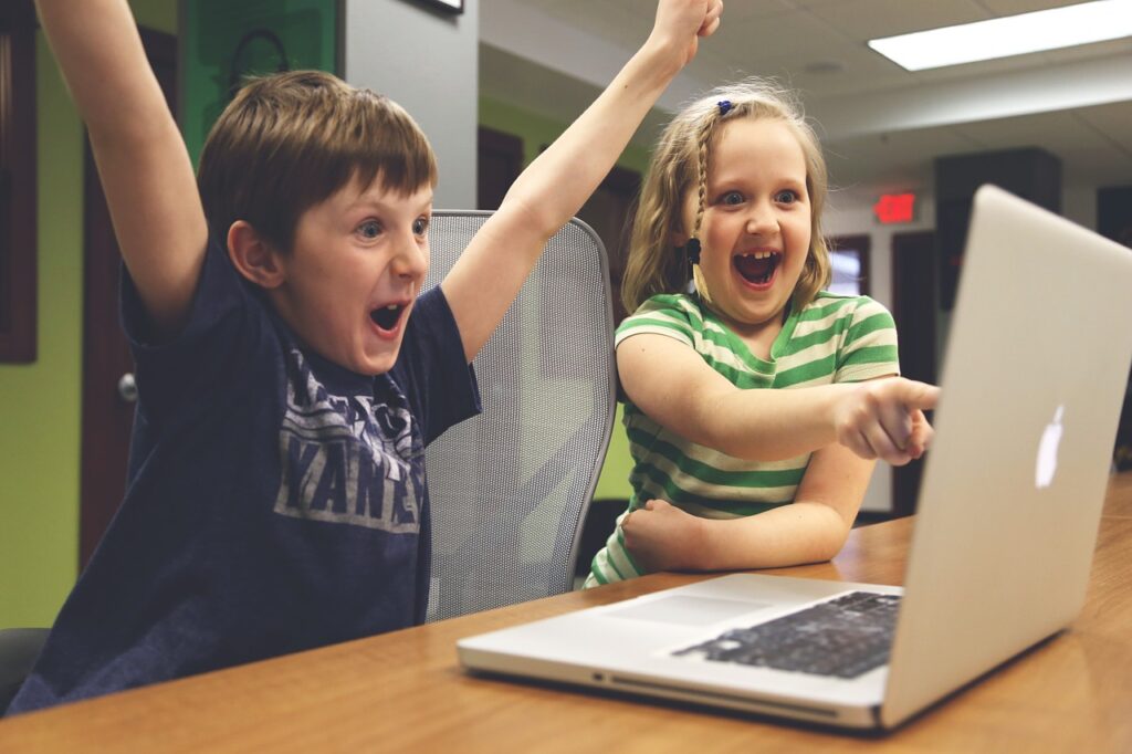 Excited children pointing at a laptop