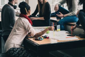 group of people cooperating on a shared project sitting around a desk